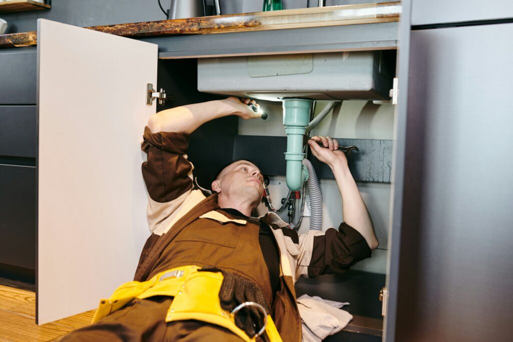 plumber fixing the underneath of a sink